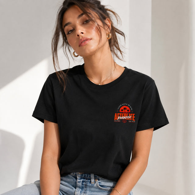 Schwarzes Unisex T-Shirt mit großem orange-weißem AFTERLIFE PARADISE Backprint, Palmen-Sonnenuntergang und Streetwear-Design an einem Zaun.