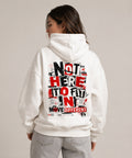 Weißer Oversized Hoodie mit kleinem MOVE DIFFERENT Frontprint und großem NOT HERE TO FIT IN Backprint in Rot und Schwarz.
